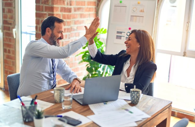Two business owners are celebrating the successful integration of the top proposal software in their organization.